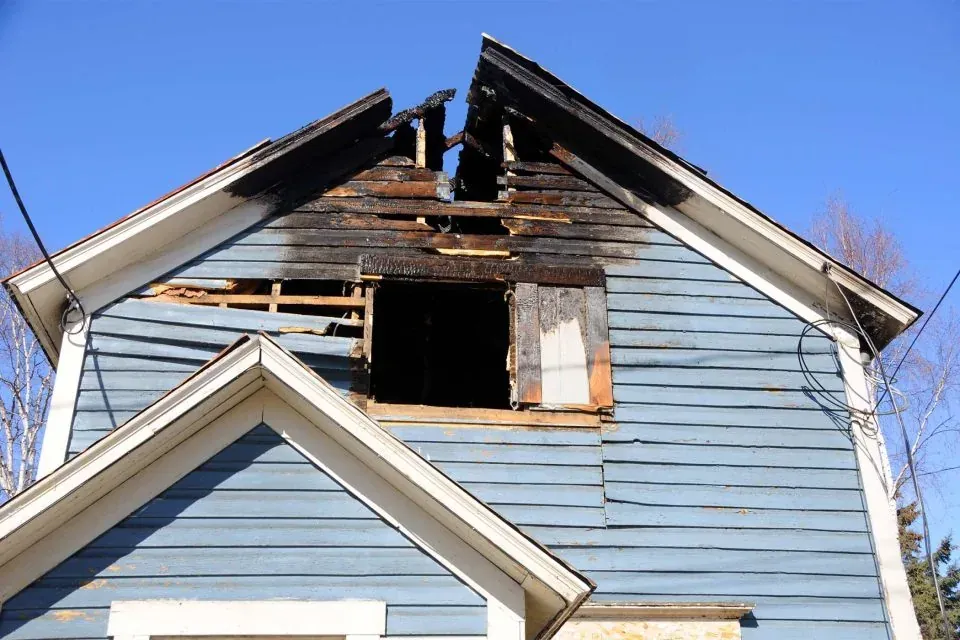 Fire-damaged home exterior in Fort Bragg, CA before restoration by North Coast Restoration