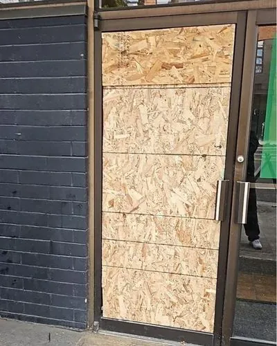 Emergency board-up securing a damaged storefront entry in Mendocino County
